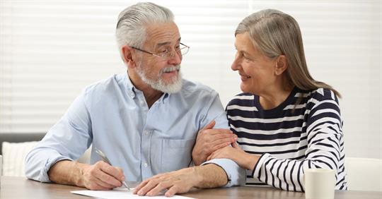 Senior Couple Signing Last Will and Testament Indoors